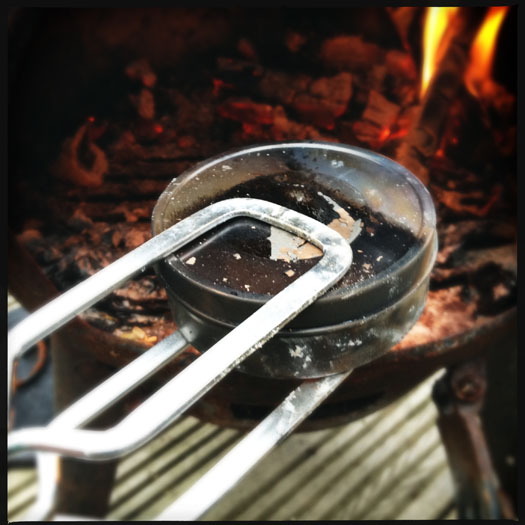 Removing char cloth tin from the fire Removing char cloth tin from the fire
